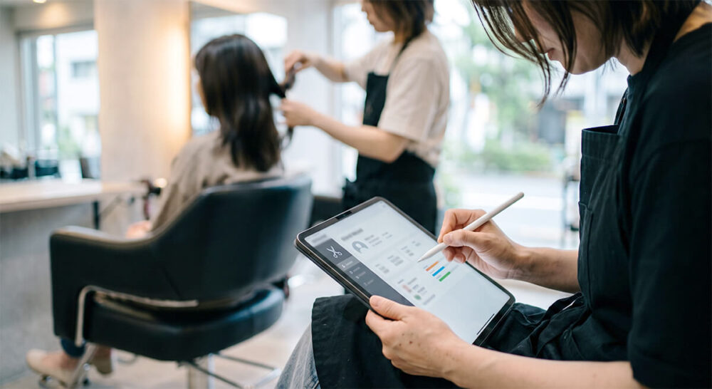 施術中にお客様の膝元でiPadとApple Pencilを操作する様子